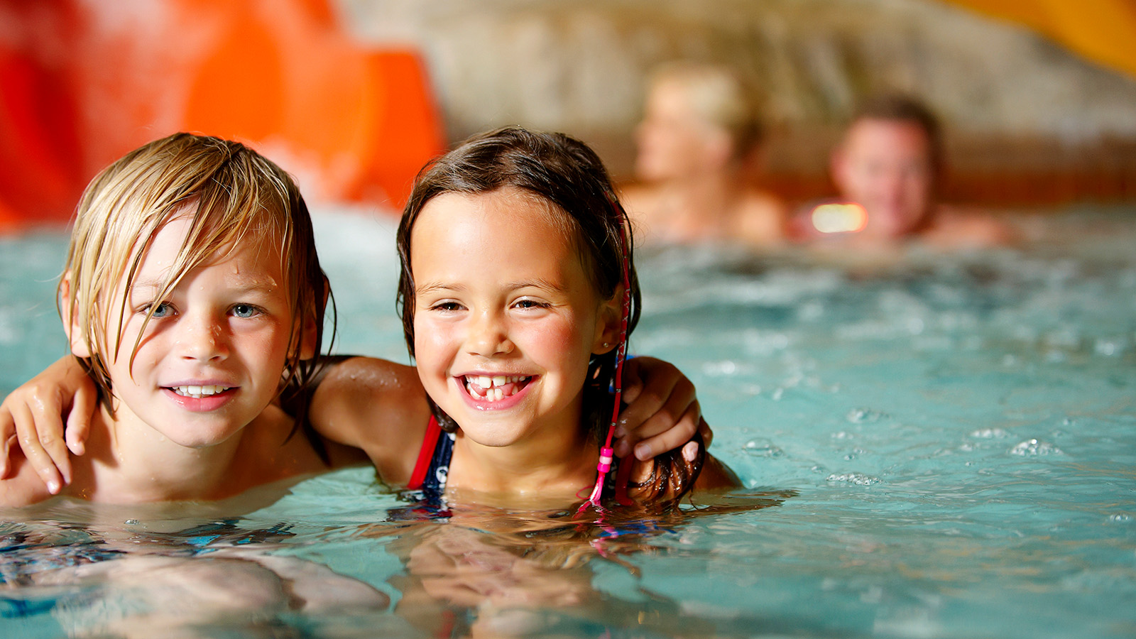 Leg i bølger eller flyd med vandstrømmen. Prøv de sjoveste vandrutsjebaner eller nyd de varme bassiner, som pigen og drengen gør det.