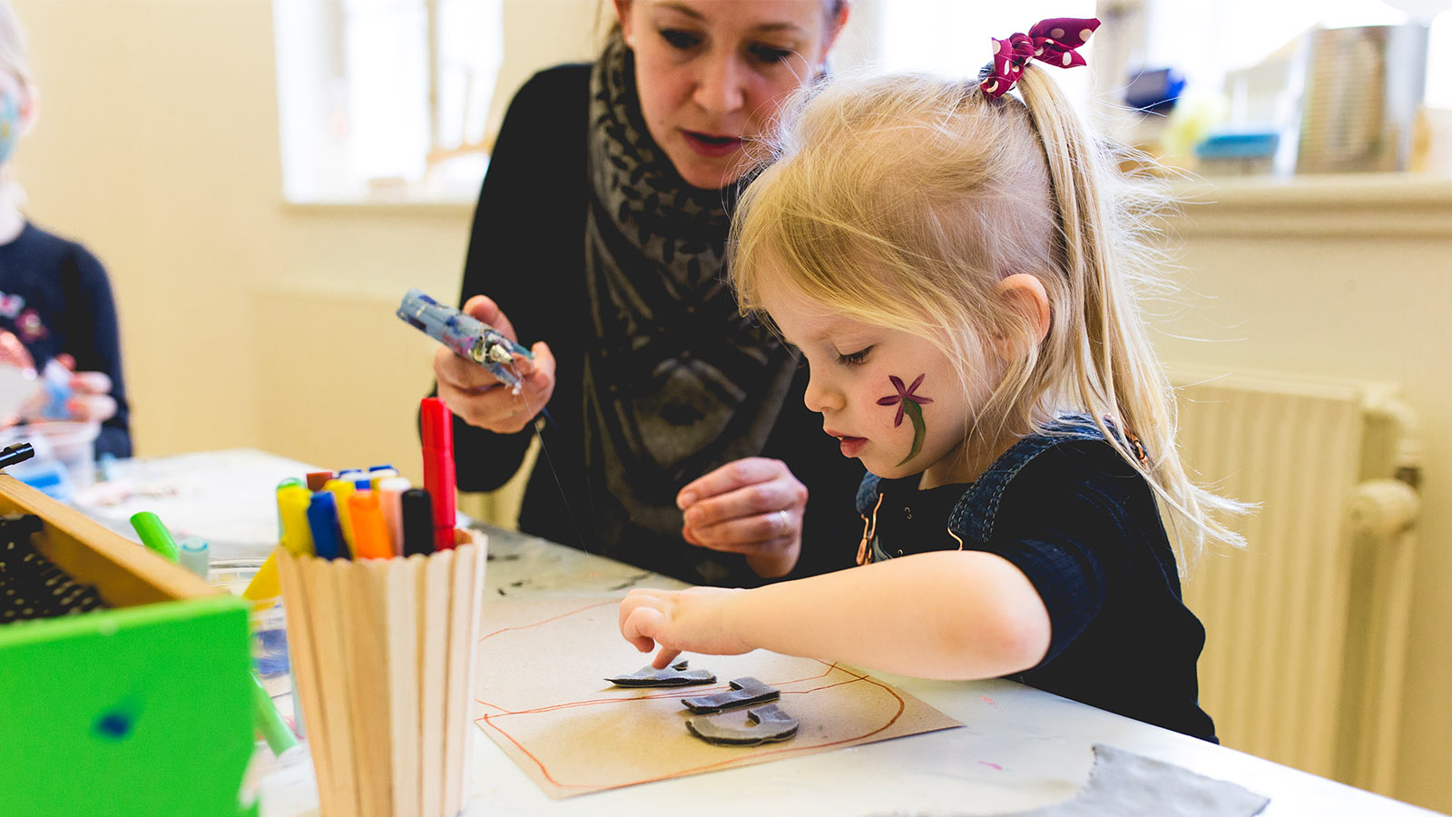 Vær kreativ som pigen her. I oplevelseshuset Nicolai for børn kan du lime, klippe og male. Klatre i tove og bygge med puder. Udforske sanserummet og meget mere. En dejlig dag i verdens bedste børnefamilie-ferie i LEGOLAND® Billund Resort.