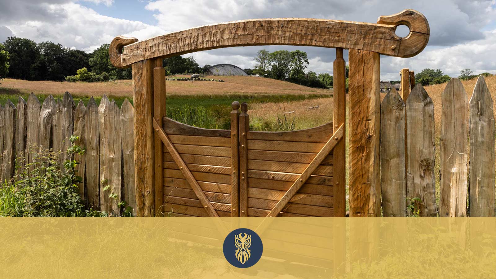 A carved wooden gate into the Lejre Land of Legends. The gate is built in strong beams with a snake head at each end of the overlying beam.