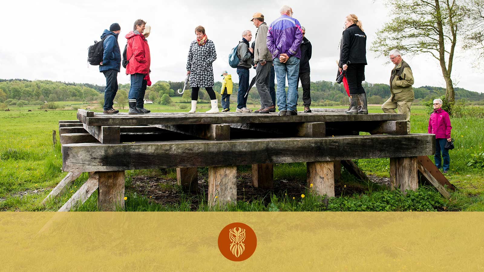 A group of people trying to stand on the reconstruction of the Ravningen Bridge built on Ravning Enge. 