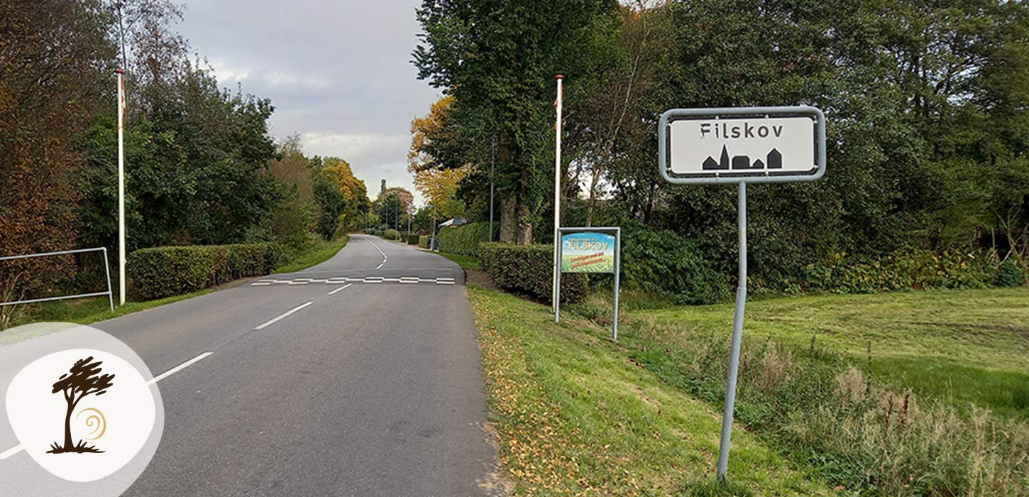 Indkørsel til Filskov by med byskilt ved vejen. Filskov er en del af Small Wonders-ruten.