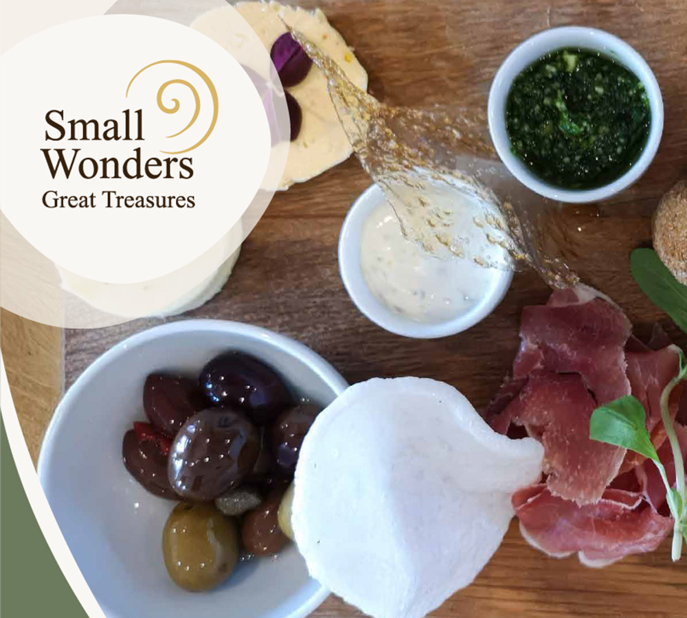 Anretning med lokale specialiteter som oste, oliven, skinke og dips set ovenfra. Introduktionsbillede til Gastroruten i Small Wonders – Heart of Jutland.