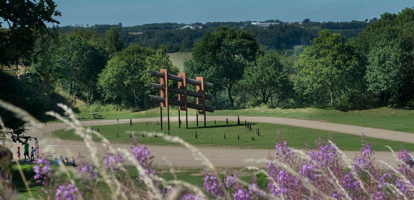 kulptur af Robert Jacobsen i Tørskind Grusgrav, omgivet af grønne bakker, træer og vilde blomster. Grusgraven er et stop på Kunstruten i Small Wonders – Heart of Jutland.
