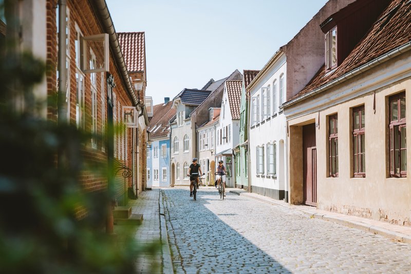 Fietsers rijden door Aabenraa Slotsgade in Sønderjylland in Zuid Jutland, Denemarken